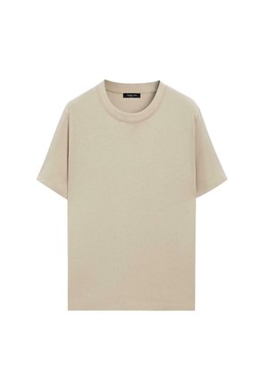 T-shirt beige a maniche corte con scollo rotondo, cuciture visibili e etichetta del marchio nera all'interno del colletto.