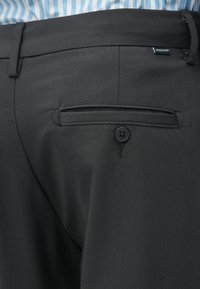 Pantaloni negri cu o textură netedă, având o buzunar din spate cu nasture și o cusătură. Talie este echipată cu un eticheta de la "Jack & Jones."