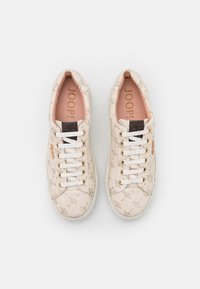 Baskets crème à motif avec lacets blancs, œillets dorés, étiquette noire sur la languette et semelles intérieures roses marquées "JOOP!", vues de dessus.