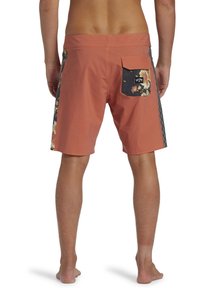Shorts de bain pour hommes en tissu corail avec une poche arrière à motifs floraux et des accents latéraux. Ils présentent une coupe standard et une taille élastique.