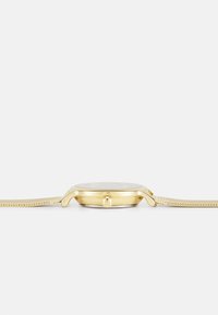 A golden watch with a slim metallic mesh band, round case, and a small crown on the side, featuring a smooth, clear watch face.
