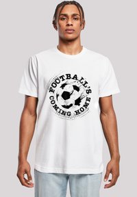 White cotton t-shirt featuring a black graphic of a soccer ball with the text "Football's Coming Home" in a distressed font. Regular fit.