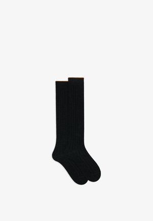 Schwarze, gerippte Kniestrümpfe mit glatter Textur und orangefarbenem Akzent am oberen Rand. Das Design zeigt ein klassisches, einheitliches Strickmuster.