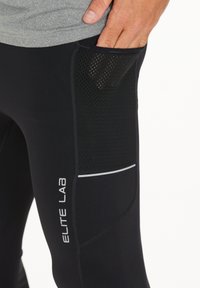 Schwarze Sporthosen mit einer strukturierten Mesh-Tasche, reflektierenden Details und dem "ELITE LAB" Logo. Hergestellt aus einem glatten, dehnbaren Material.