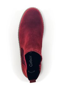 Scarpa slip-on rossa in suede con pannelli elastici laterali e suola in gomma. Presenta una parte superiore testurizzata e un piccolo passante sul tallone.