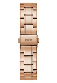 Montre en métal rose doré avec un design de bracelet à maillons. Présente une finition polie et un fermoir avec le logo 'GUESS' en relief. Maillons rectangulaires.