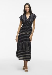 Abito lungo navy con strisce a fantasia in beige. Presenta maniche corte, scollatura a V e una vita con coulisse per una vestibilità regolabile.