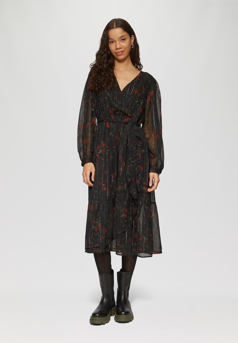 Schwarzes Blumen-Wickelkleid mit langen Ärmeln, das einen gestuften Rock, einen gerafften Saum und einen Stoffgürtel aufweist. Strukturiertes, durchsichtiges Material mit roten Akzenten.