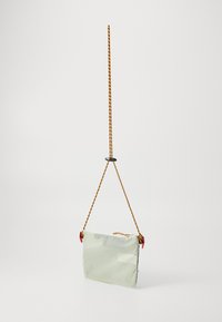 Bolsa rectangular de color verde claro, hecha de material suave. Presenta un cierre de cremallera, acentos rojos y una correa trenzada amarilla y morada para llevar.