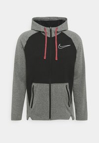 Haut à capuche zippé avec un panneau noir sur le devant supérieur et des manches grises, doté de cordons rouges, d'un logo blanc et de deux poches latérales.