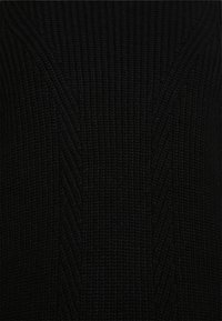 Sweater preto de malha com um design texturizado e padrões diagonais. O tecido parece suave e aconchegante.