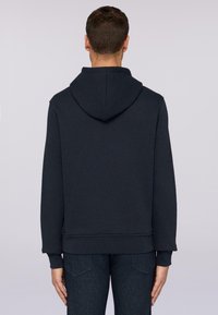 Hoodie i mörk marinblått med ribbade ärmslut och nederkant, tillverkad av en mjuk bomullsblandning. Den har en klassisk passform och en slät textur.