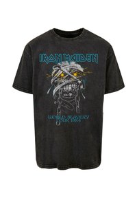 Tricou negru din bumbac cu un imprimeu grafic ce prezintă un craniu, lanțuri și textul "Iron Maiden" în albastru, cu accente de fulgere.
