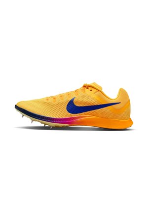 Chaussure de sport jaune avec une tige texturée, un logo bleu et une semelle dégradée du violet au rose. Équipée de pointes sur la semelle extérieure pour une meilleure adhérence.