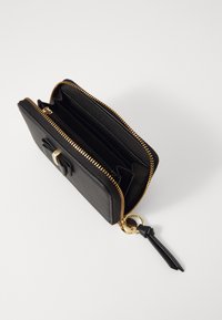 Black leather wallet with gold zipper, featuring multiple compartments, a zip pocket, and a decorative bow detail on the front.