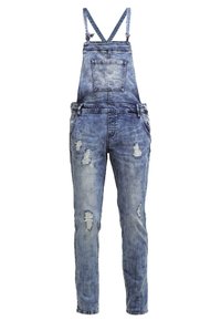 Salopette en denim bleu avec bretelles ajustables, poche poitrine avant, poches latérales, et déchirures usées sur les jambes.