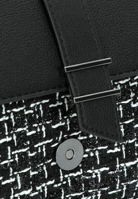 Borsa a tracolla in tweed bianco e nero con corpo testurizzato, parte superiore in pelle liscia, chiusura in metallo argentato e dettaglio di chiusura magnetica.