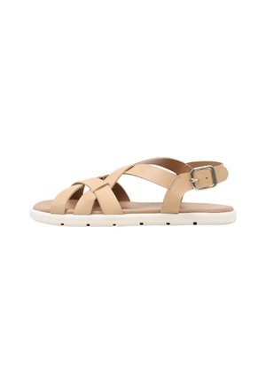 Sandalia plana beige con tiras cruzadas, cierre de hebilla y suela de goma blanca.