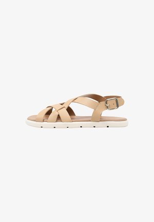 Sandalia plana beige con tiras cruzadas, cierre de hebilla y suela de goma blanca.