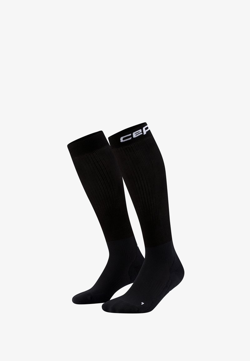 Paar schwarze kniehohe Kompressionssocken mit gerippter Struktur und weißer Logo-Beschriftung am oberen Rand.
