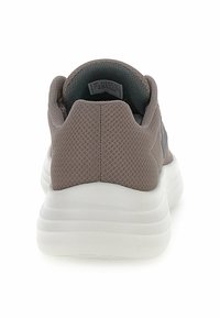 Gray textile sneaker with a mesh finish, rounded heel, and white cushioned sole. Features minimalistic design and no visible branding.