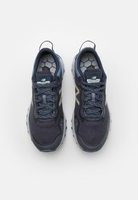 Zapatillas de running para hombre con parte superior de malla en azul marino oscuro, detalles en gris y suela con patrón hexagonal. Cuenta con cordones y una plantilla acolchada Fresh Foam.