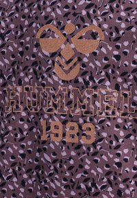 Hummel-märkt topp med leopardmönster i nyanser av lila och svart, med gyllene bokstäver för "HUMMEL 1923."