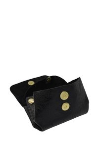 Pochette à pièces en cuir noir texturé avec fermetures à bouton-pression doré, partiellement ouverte, montrant la doublure intérieure et un bouton supplémentaire.