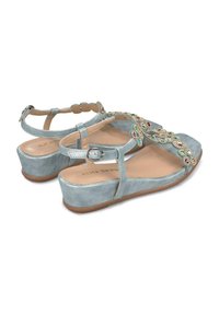 Sandales à talons compensés en suede bleu clair avec embellissements décoratifs, une sangle réglable et une semelle texturée. Conçues avec un dos fermé.