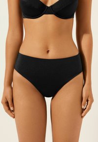 Czarny bikini o wysokim stanie, wykonany z gładkiego materiału, z prostym wzornictwem. Brak widocznych wzorów lub detali z hardware.