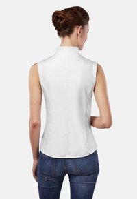 Weißes ärmelloses Blusenshirt mit hohem Kragen, glatter Textur und taillierter Passform. Verfügt über eine zentrale Naht und einen abgerundeten Saum auf der Rückseite.