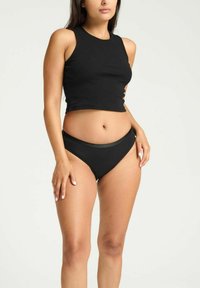 Top court noir côtelé et haut de bikini taille haute assorti. Les deux ont un design ajusté et une texture lisse. Pas de motifs visibles.