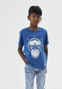 Camiseta de algodón azul con un gráfico de una calavera con un sombrero de capitán y barba, rodeada por un círculo con acentos naranjas y azules.