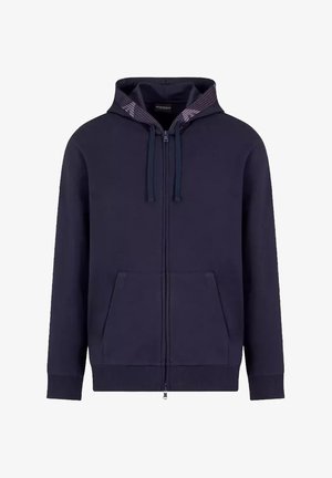 Felpa con zip colore navy, con una texture a coste, cordini e due tasche anteriori. Presenta un rivestimento a motivo nella cappuccio.