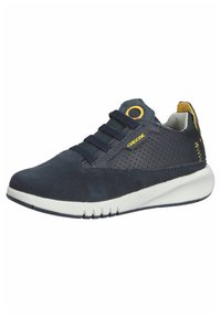 Zapatilla azul marino con materiales de ante y malla, que presenta una suela blanca, detalles en amarillo y seis ojales para un ajuste seguro.