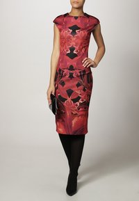 Robe bodycon rouge à motifs floraux avec manches courtes, sur fond noir. Le design comprend des motifs vibrants et une silhouette ajustée.
