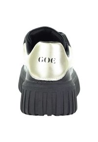 Czarne sneakersy z grubą, żłobioną podeszwą, metaliczną, srebrną naszywką na pięcie i czarnym logo "GOG" z tyłu, widok z tyłu.