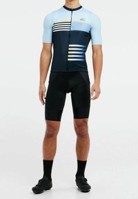 Maillot de cyclisme à manches courtes en bleu clair et marine avec des rayures horizontales, associé à un short rembourré noir et des chaussures de cyclisme noires.