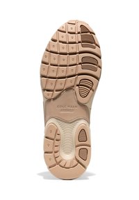 Sole di sneaker color beige chiaro con gomma testurizzata. Presenta scanalature per aderenza, bordi arrotondati e logo del marchio. Tallone rinforzato per stabilità.