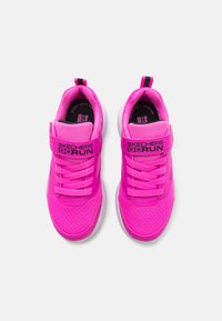 Roosa võrgusilma spordijalatsid pehmendatud kaelakaarega, takjapaela ja nööridega. Omab valget kummist tallat ja "Skechers Go Run" brändingut.