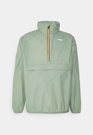 Veste pull-over vert clair avec un col haut, une fermeture éclair avant sur la moitié avec une bordure jaune et noire, et une poche avant à rabat.
