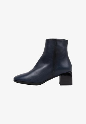 Bottine en cuir marine à bout pointu et talon carré brillant. Texture lisse avec un minimum de détails de couture.