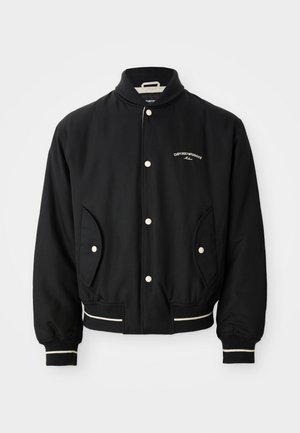 Veste bomber noire avec un col côtelé, fermeture à boutons-pression, deux poches latérales et des accents rayés blancs aux poignets et à l'ourlet.