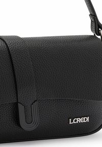 Schwarze Lederhandtasche mit strukturierten Oberflächen, schlankem Design und einem auffälligen Logo-Detail. Enthält einen verstellbaren Tragegurt und einen einzigartigen Verschluss.