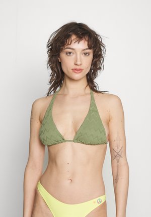 Zöld háromszög alakú bikini felsőrész, amelyet bordázott cikk-cakk mintázat díszít, sárga bikini alsóval, amelyen béke jel és csillag motívumok találhatók.
