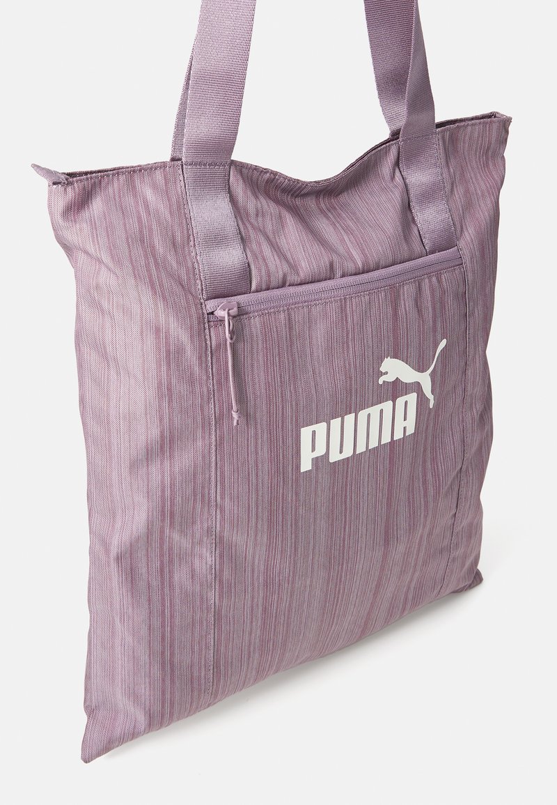 Borsa a tracolla a righe viola in tessuto, con manici robusti, una tasca frontale con zip e il logo PUMA bianco sul lato.