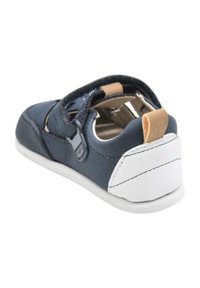 Zapato azul marino con acentos blancos, con un diseño resistente, correa ajustable y forro interior suave. Fabricado con materiales de cuero y goma.