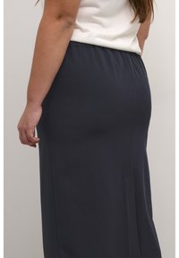 Tmavomodrá maxi sukňa vyrobená z mäkkého materiálu, so elastickým pásom a bočnou kapsou, zobrazená zozadu.