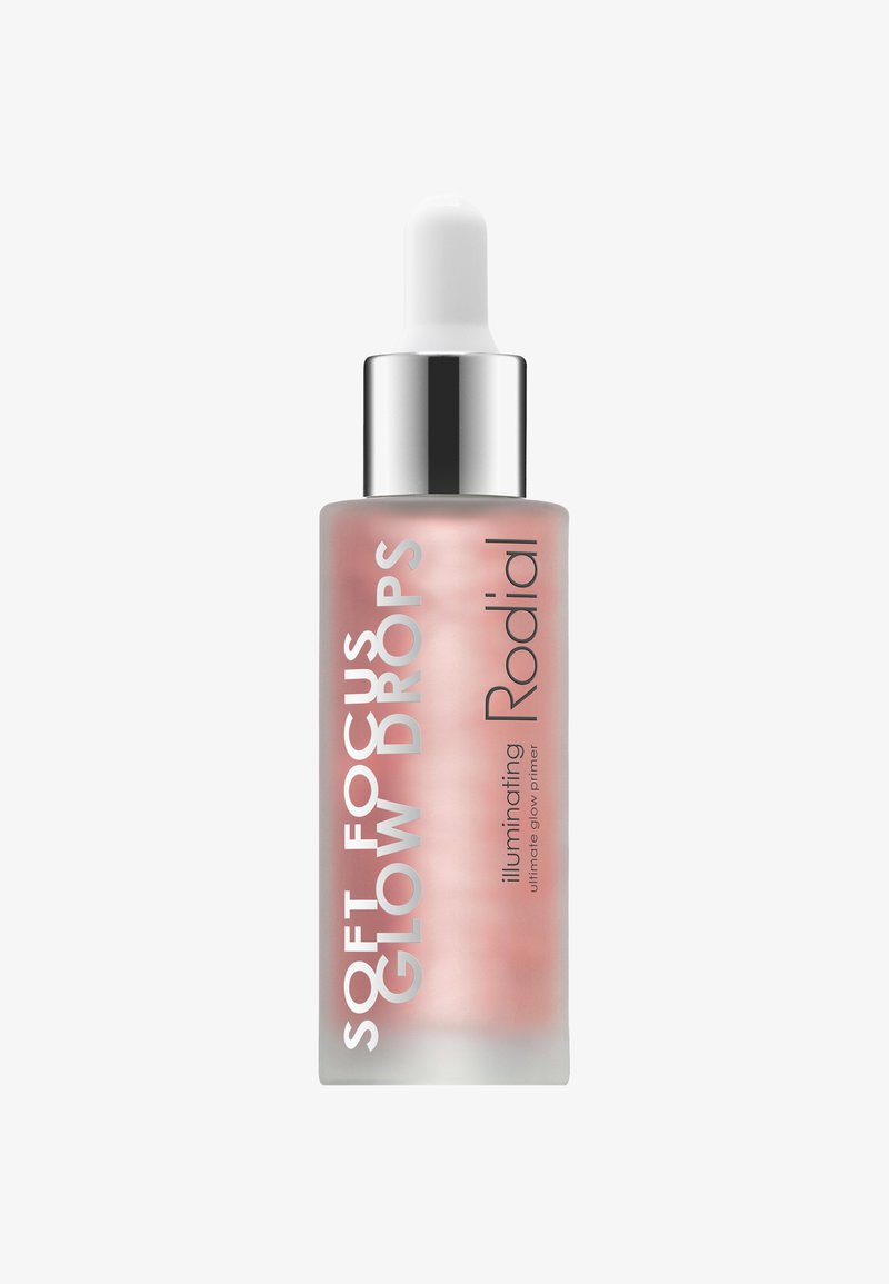 Transparente Glasflasche mit einem verlaufenden rosa Farbton, ausgestattet mit einer weißen Pipette und silbernen Akzenten. Der Etikettentext enthält "Soft Focus Glow Drops" und "Rodial."