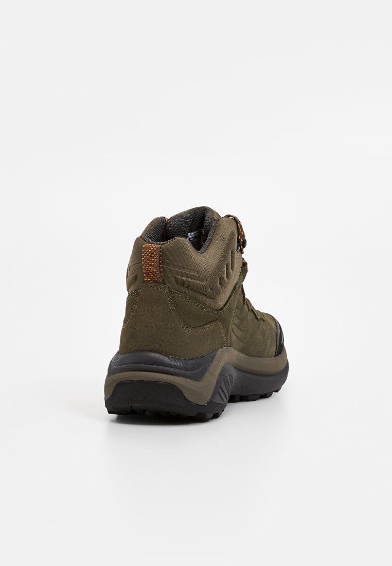 Groene wandelschoenen met een gestructureerde stoffen bovenkant, een gevoerde kraag en een zwarte rubberen zool. Heeft een contrasterende oranje accenten op de hiel.